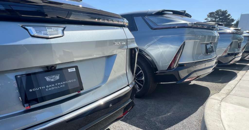 Luxury, Meet Tech: The Digital License Plate Lands at Cadillac of South San Francisco 1 An image of a row of Silver Cadillac Lyriq vehicles with digital license plates.