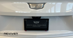Image of a white Cadillac with a digital license plate.